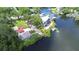 Aerial view of a waterfront home with private dock and lush landscaping in a serene setting at 8001 N Highland Ave, Tampa, FL 33604