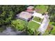 Aerial view of the property overlooking a serene waterfront with lush landscaping at 8001 N Highland Ave, Tampa, FL 33604