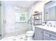 Modern bathroom featuring a glass-enclosed shower, tiled walls and floor, and vanity with a sink at 8001 N Highland Ave, Tampa, FL 33604