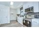 Bright kitchen features white cabinets, stainless steel appliances, and gray backsplash at 8001 N Highland Ave, Tampa, FL 33604