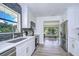 Open-concept kitchen with new stainless steel appliances, white cabinets, and lots of natural light at 8001 N Highland Ave, Tampa, FL 33604