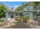 Backyard featuring a patio with a blue picnic table, lush garden, and charming landscaping at 8014 27Th N Ave, St Petersburg, FL 33710