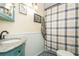 Compact bathroom with a granite vanity top, toilet, and shower with a blue and white curtain at 8014 27Th N Ave, St Petersburg, FL 33710