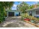 Exterior of house with garage, lush green lawn, and patio with a blue picnic table at 8014 27Th N Ave, St Petersburg, FL 33710