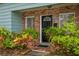 Home's front door framed by brick, adorned with lush greenery and vibrant plants at 8014 27Th N Ave, St Petersburg, FL 33710