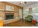 Cozy living room with brick fireplace, hardwood floors and natural light from the large window at 8014 27Th N Ave, St Petersburg, FL 33710