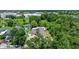 Aerial view of a single-Gathering home surrounded by lush greenery, with a driveway and residential street at 8105 N Grady Ave, Tampa, FL 33614