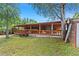 Spacious covered deck with wooden railing overlooking the lawn in the backyard at 8105 N Grady Ave, Tampa, FL 33614