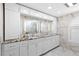 Spacious bathroom featuring dual sinks, granite countertops, white cabinetry, and marble tile flooring at 8105 N Grady Ave, Tampa, FL 33614