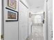 Hallway leading to an elegant bathroom with marble flooring, a window, and artistic wall decor at 8105 N Grady Ave, Tampa, FL 33614
