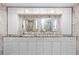 Spacious bathroom with dual sinks, granite counters, white cabinetry, and decorative mirrors at 8105 N Grady Ave, Tampa, FL 33614