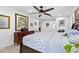 Bright bedroom showcasing a ceiling fan, a large painting, and a glimpse into an ensuite bathroom at 8105 N Grady Ave, Tampa, FL 33614