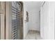 Hallway featuring a secure metal grate entry door, marble tile floor, and two hallway storage closets at 8105 N Grady Ave, Tampa, FL 33614