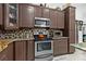 Kitchen area with stainless steel oven, microwave, tiled backsplash, and granite countertop at 8105 N Grady Ave, Tampa, FL 33614