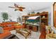 Spacious living room with tile floors, a large tv, and a comfortable orange couch at 8105 N Grady Ave, Tampa, FL 33614
