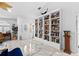 Bright living room featuring marble floors and a built-in bookshelf filled with an abundance of books and decor at 8105 N Grady Ave, Tampa, FL 33614