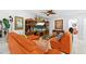 Cozy living room with tile floors, a large tv, and an orange reclining couch at 8105 N Grady Ave, Tampa, FL 33614