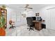 Office space featuring a large wood desk with multiple monitors, a ceiling fan, and bright, natural light at 8105 N Grady Ave, Tampa, FL 33614