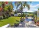 Manicured backyard with a patio seating area, lush lawn, mature landscaping and fencing at 917 Pineview Ave, Clearwater, FL 33756