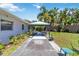 Well-maintained backyard featuring a covered gazebo with seating, lush landscaping, and tropical palm trees at 917 Pineview Ave, Clearwater, FL 33756