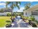 Backyard with a covered seating area, mature landscaping, and a concrete walkway at 917 Pineview Ave, Clearwater, FL 33756