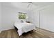Bright bedroom with hardwood floors, neutral walls, ceiling fan and white bed at 917 Pineview Ave, Clearwater, FL 33756