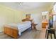 Bedroom with a light wood bed frame, ceiling fan, and view into the updated bathroom at 917 Pineview Ave, Clearwater, FL 33756