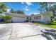Single-story home featuring a well-manicured lawn and a two-car garage, with trees providing ample shade at 917 Pineview Ave, Clearwater, FL 33756