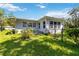 The back of the home features a lush green lawn and meticulous landscaping with many windows and natural light at 917 Pineview Ave, Clearwater, FL 33756
