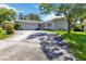 Charming single-story home featuring a well-manicured lawn and a two-car garage on a sunny day at 917 Pineview Ave, Clearwater, FL 33756