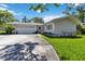 Charming single-story home featuring a well-manicured lawn and a two-car garage on a sunny day at 917 Pineview Ave, Clearwater, FL 33756