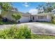 Single-story home featuring a well-manicured lawn, two-car garage, and charming landscaping for added curb appeal at 917 Pineview Ave, Clearwater, FL 33756