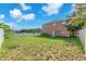Large backyard with manicured lawn, mature trees, and white picket fence at 10523 Boyette Creek Blvd, Riverview, FL 33569
