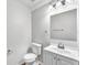 Well-lit half bathroom with white fixtures and a sleek, modern design at 10523 Boyette Creek Blvd, Riverview, FL 33569