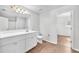 Bright bathroom featuring wood-look floors, double vanity with modern fixtures, and a walk-in closet at 10523 Boyette Creek Blvd, Riverview, FL 33569
