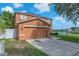 View of the home's garage and driveway, with a serene lake in the background at 10523 Boyette Creek Blvd, Riverview, FL 33569