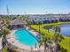 Overhead shot of a community pool and a pond, with palm trees and lounge chairs around the pool deck at 11519 Crowned Sparrow Ln, Tampa, FL 33626