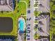 Aerial view of a community pool, lined with palm trees and lounge chairs, next to residences at 11519 Crowned Sparrow Ln, Tampa, FL 33626