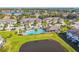 Aerial view of a pond, pool, clubhouse and townhomes in a well-maintained community with tropical accents at 11519 Crowned Sparrow Ln, Tampa, FL 33626