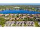 Bright aerial view of colorful lakeside townhomes surrounded by lush green trees on a sunny day at 11519 Crowned Sparrow Ln, Tampa, FL 33626