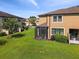 Backyard view of a two-story home with a screened-in porch, patio and spacious lawn at 11519 Crowned Sparrow Ln, Tampa, FL 33626