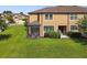Backyard view of a two-story home with a screened-in porch, grill, patio and spacious lawn at 11519 Crowned Sparrow Ln, Tampa, FL 33626
