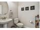 Half bathroom with pedestal sink, neutral color palette, decorative wall art and modern fixtures at 11519 Crowned Sparrow Ln, Tampa, FL 33626