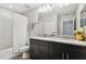 Bathroom showcases double sinks, granite countertops, black cabinets and a tiled shower-tub combo with modern fixtures at 11519 Crowned Sparrow Ln, Tampa, FL 33626