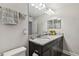 Bathroom featuring a double vanity with granite countertops, dark cabinets, and decorative accents at 11519 Crowned Sparrow Ln, Tampa, FL 33626