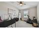 Neutral bedroom with a ceiling fan, a desk, and fitness equipment at 11519 Crowned Sparrow Ln, Tampa, FL 33626