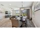 Open concept dining and living area with a stylish chandelier, wood floors, and backyard view at 11519 Crowned Sparrow Ln, Tampa, FL 33626