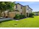 Inviting two-story townhome with lush landscaping, a well-manicured lawn, and a warm, welcoming facade at 11519 Crowned Sparrow Ln, Tampa, FL 33626