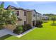 Charming two-story home with a well-manicured lawn, decorative shutters, and view of a nearby pond at 11519 Crowned Sparrow Ln, Tampa, FL 33626