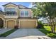 Two-story home boasts a spacious garage, beautiful landscaping, and a sunny front yard with flowering trees at 11519 Crowned Sparrow Ln, Tampa, FL 33626